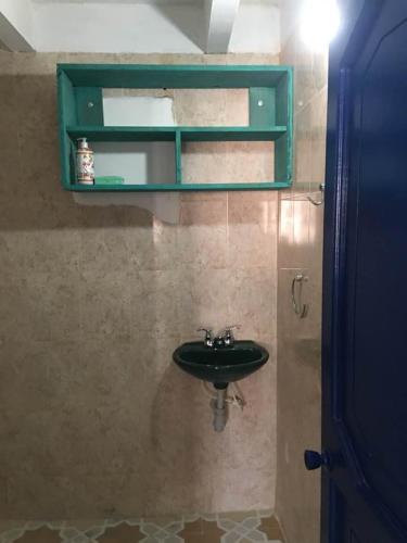 a bathroom with a sink and a green cabinet at CASAMARAZUL Beach house in Santa Marta
