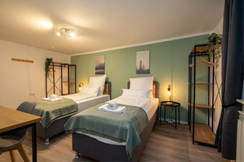 two beds in a room with green walls at Sali Homes Übernachten im Kulturdenkmal - Weinort in Besigheim
