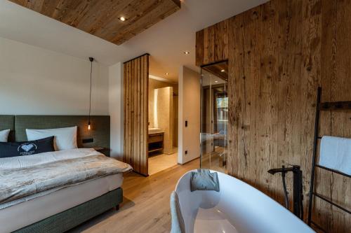 a bedroom with a large bed and a bath tub at Jaggling Appartements in Sankt Ulrich am Pillersee