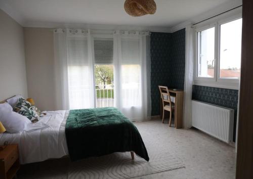 a bedroom with a bed and a desk and windows at Le Gîte de Mellonia - 7 chambres in Pouzauges