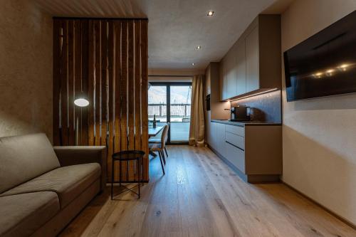 a living room with a couch and a kitchen with a table at Jaggling Appartements in Sankt Ulrich am Pillersee