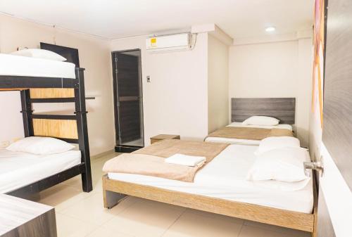 a bedroom with two bunk beds and a bathroom at HOTEL DASANTO HD in Barranquilla