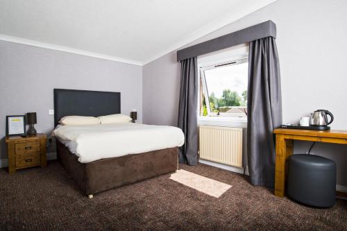 Schlafzimmer mit einem Bett und einem Fenster in der Unterkunft Douglas Arms Hotel in Banchory