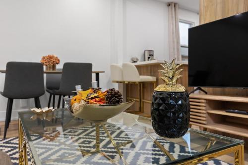 a living room with a bowl of fruit on a glass table at Private House with parking & steps to subway in Toronto