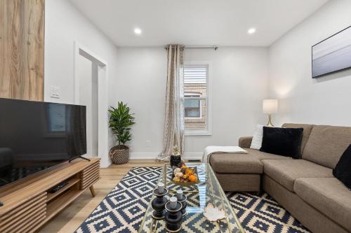 a living room with a couch and a flat screen tv at Private House with parking & steps to subway in Toronto