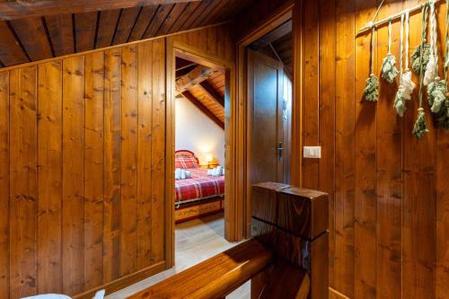 a room with wooden walls and a room with a bed at 3 Minuti da Asiago - Zona Tranquilla e Silenziosa in Gallio