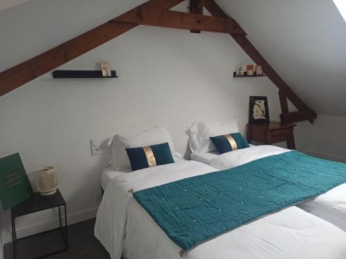 a bedroom with two beds with a green blanket on them at Gîtes Le Meslaysien in Meslay-du-Maine