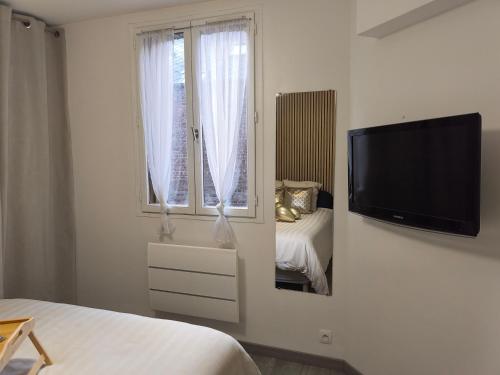 - une chambre blanche dotée d'une télévision murale à écran plat dans l'établissement T2 Moderne Centre Ville, au Havre