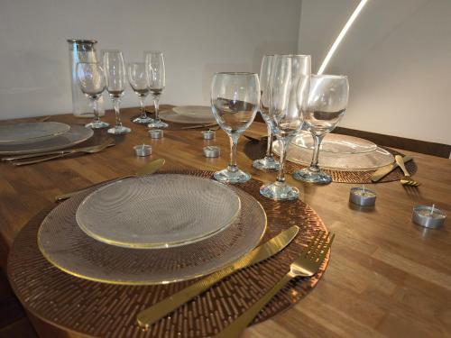 - une table avec des assiettes et des verres à vin sur une table en bois dans l'établissement T2 Moderne Centre Ville, au Havre