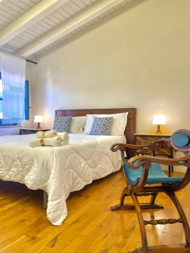 a bedroom with a bed and a chair and a table at Casale Di Benedetto in Caltagirone