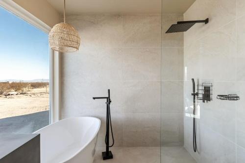 a bathroom with a tub and a sink and a shower at Shangrila By The Cohost Company in Joshua Tree