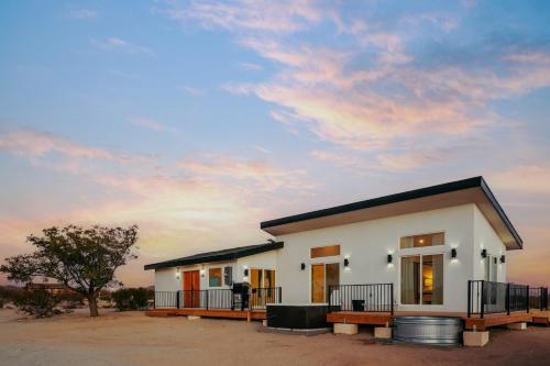 a small white house with a cloudy sky at Shangrila By The Cohost Company in Joshua Tree