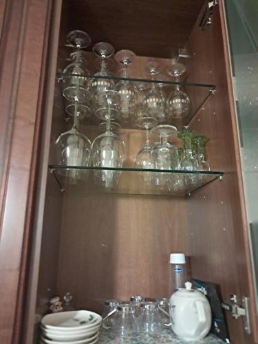 un estante lleno de tarros y tazones de vidrio y un fregadero en Roses house, en Porto San Giorgio