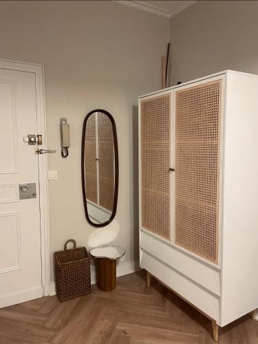 La salle de bains est pourvue d'un miroir et d'une armoire blanche. dans l'établissement Le cocon de Rouen, à Rouen