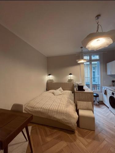 une chambre avec un lit et une table et une cuisine dans l'établissement Le cocon de Rouen, à Rouen