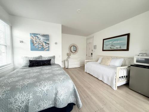 a bedroom with a bed and a bed and a window at Windward at the Beach in Beach Haven