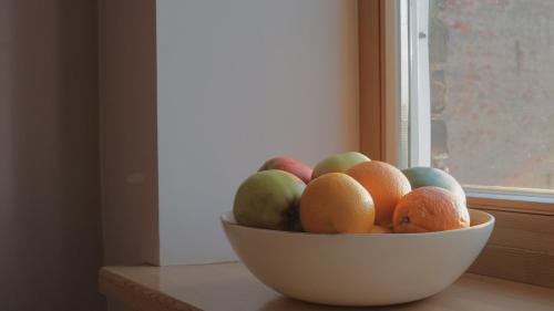 a bowl of fruit sitting on a window sill at MOODar RENT in Rīga