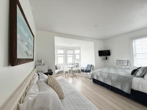a white bedroom with a bed and a couch at Windward at the Beach in Beach Haven
