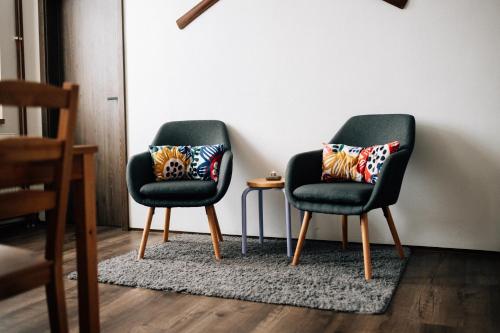 two black chairs with pillows on them in a room at Horalka Apartments in Jáchymov