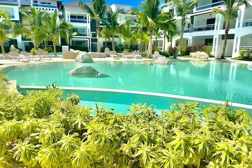 a pool at a resort with palm trees at Estrella Dominicus Advantage in Bayahibe