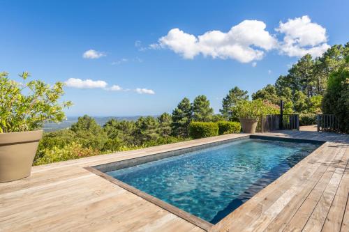 - une piscine au milieu d'une terrasse en bois dans l'établissement Domaine Kalliste Porto Vecchio, à Porto-Vecchio