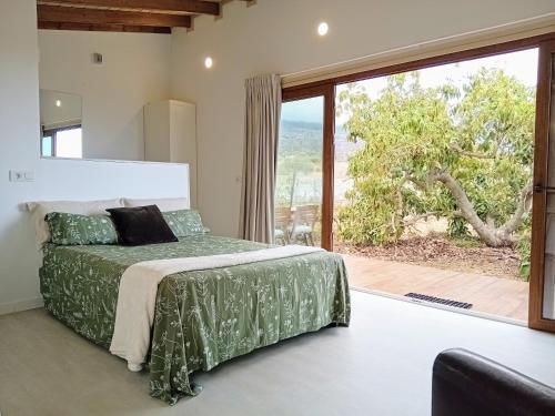 a bedroom with a bed and a large window at El Cornical Luxury Bungalows in Arafo