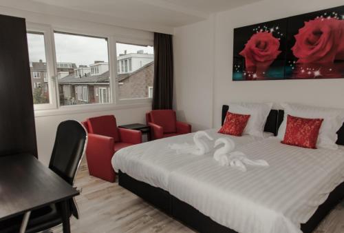 a bedroom with a bed and two red chairs at Amsterdam Soul Inn in Amsterdam