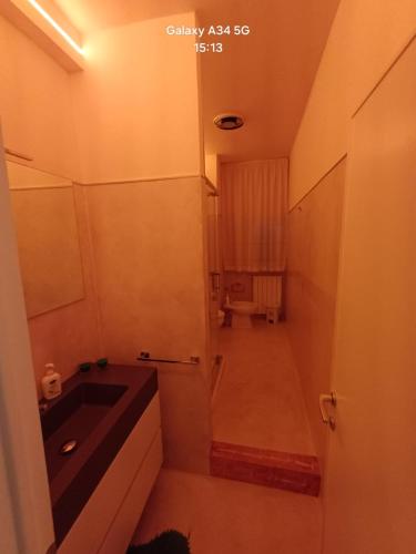 a small bathroom with a sink and a hallway at Il paradiso sotto le nuvole in Peccioli