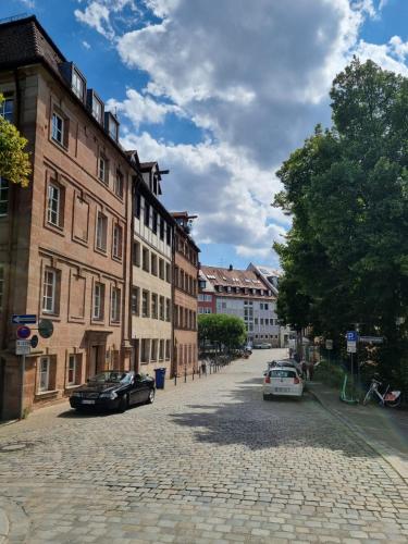 une rue pavée dans une ville avec des bâtiments dans l'établissement Altbau Charme in der Nürnberger Innenstadt, à Nuremberg