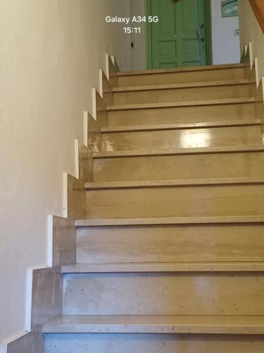 a set of stairs with a green door at Il paradiso sotto le nuvole in Peccioli