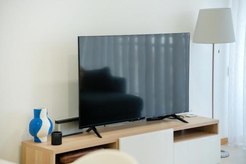 a flat screen tv sitting on a wooden stand at Apartamento Lux 1882 in Figueira da Foz