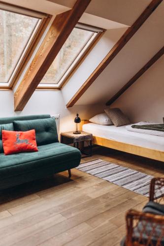 a attic bedroom with a bed and a couch at Villa Hubertus in Srebrna Góra