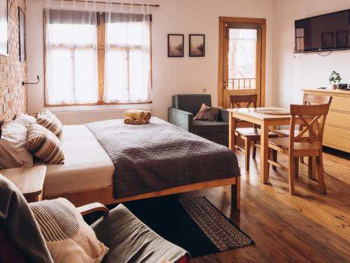 a room with two beds and a table with a teddy bear on it at Villa Hubertus in Srebrna Góra
