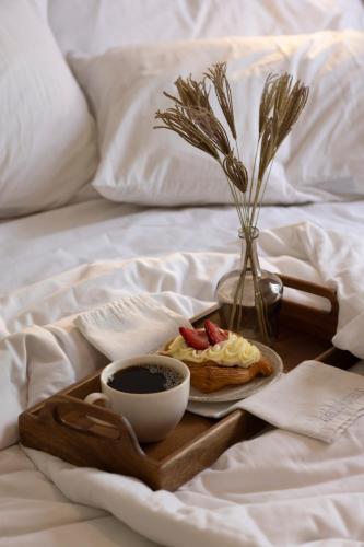a tray of food and a cup of coffee on a bed at Reforma Guest House in Mexico City