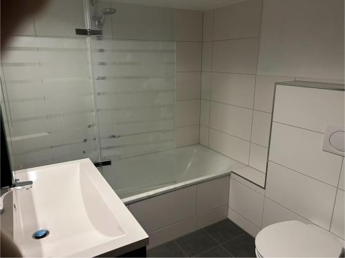 a white bathroom with a tub and a toilet at Privates Ferienzimmer Flensburg, 900 m zum Strand in Flensburg
