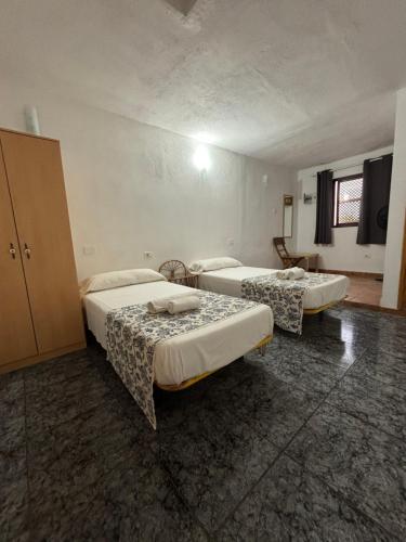 a room with two beds in a room at Apartamentos y Habitaciones Villa Marina in La Caleta