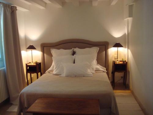 une chambre avec un lit avec des oreillers blancs et deux lampes dans l'établissement Arles les Alyscamps, à Arles