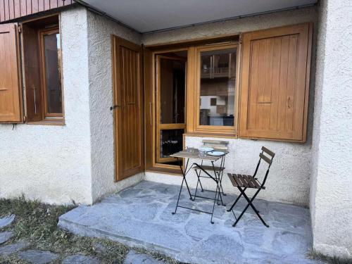 une table et deux chaises devant un bâtiment dans l'établissement Résidence Pierres Plates - Les Pierres Plates 4 - Joli studio chaleureux MAE-1871, à Valmorel