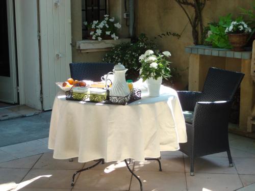 uma mesa com uma taça de fruta e um vaso sobre ela em Arles les Alyscamps em Arles
