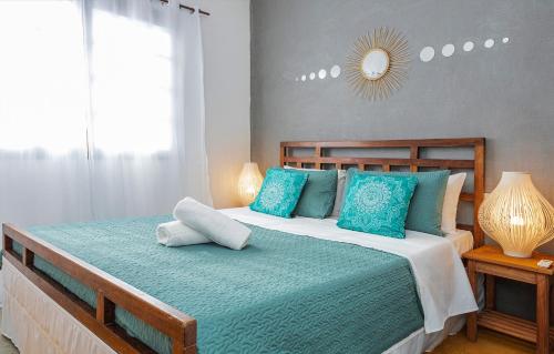 a bedroom with a large bed with blue pillows at Pousada Aysú Maresias in Maresias