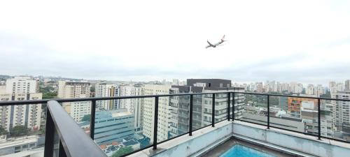an apartment balcony with a view of a city at MOEMA54 - Studio novo e completo na melhor localização de Moema, ao lado do Shopping Ibirapuera in Sao Paulo