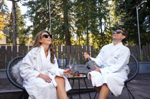 a man and woman in white robes sitting on a bench at Villa Sokol in Borovets