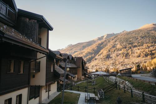 a group of buildings with mountains in the background at Appartamento a Ponte di Legno con Vista sulle Alpi in Ponte di Legno