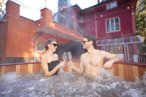 a man and woman sitting in a tub with wine glasses at Villa Sokol in Borovets