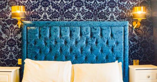 a blue headboard of a bed in a bedroom at The Pier Hotel in Eastbourne