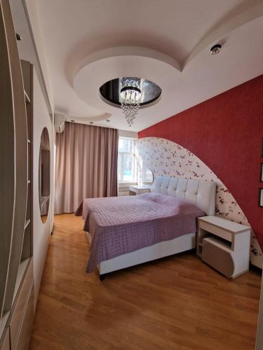 um quarto com uma cama e uma parede vermelha em Gamma em Baku