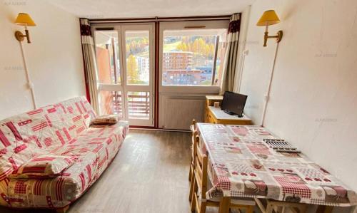 une chambre avec deux lits, un bureau et une fenêtre dans l'établissement Résidence L'aconcagua - Studio 3/4 personnes - ACONCAGUA - PLAGNE CENTRE MAE-2191, à La Plagne Tarentaise