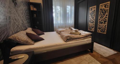 Un dormitorio con una cama con almohadas encima. en Ella Home at Dóm, en Szeged