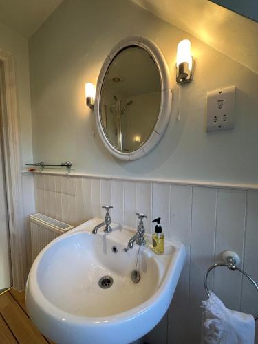 a white sink in a bathroom with a mirror at 30 Park Street in Hungerford