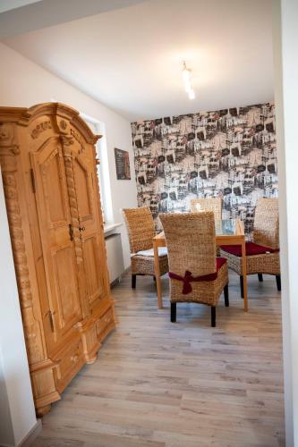 a room with a wooden cabinet and chairs and a table at Ferienwohnung am Bismarckturm in Bodenwerder